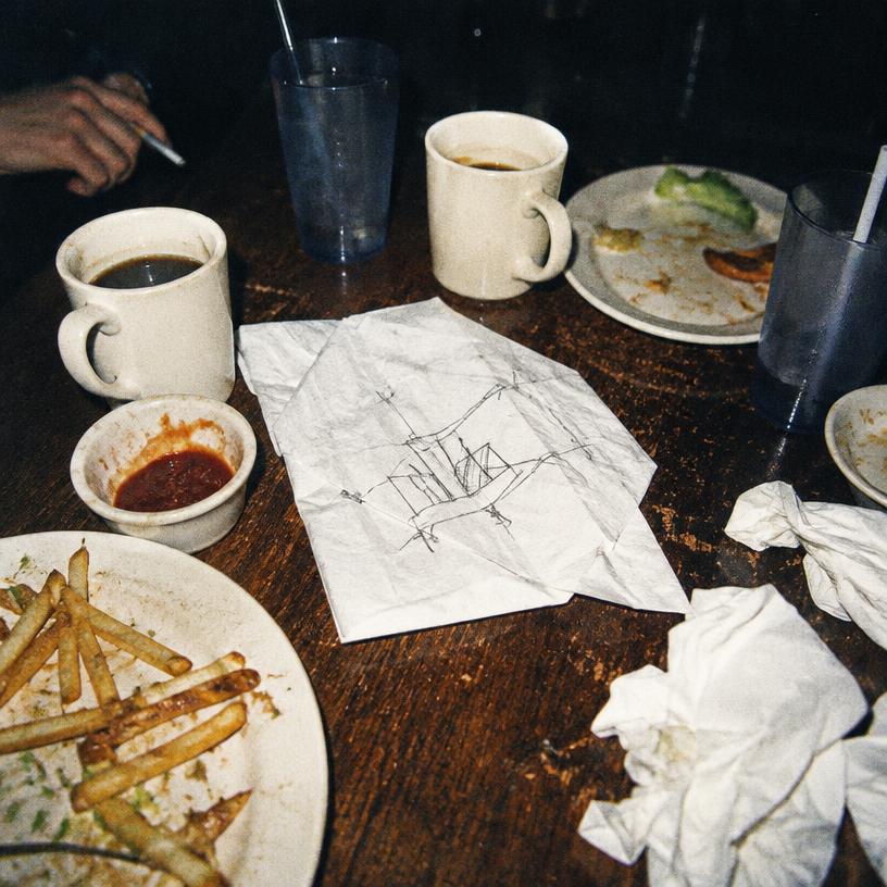 Flash photo of a diner table with a sketch on a napkin