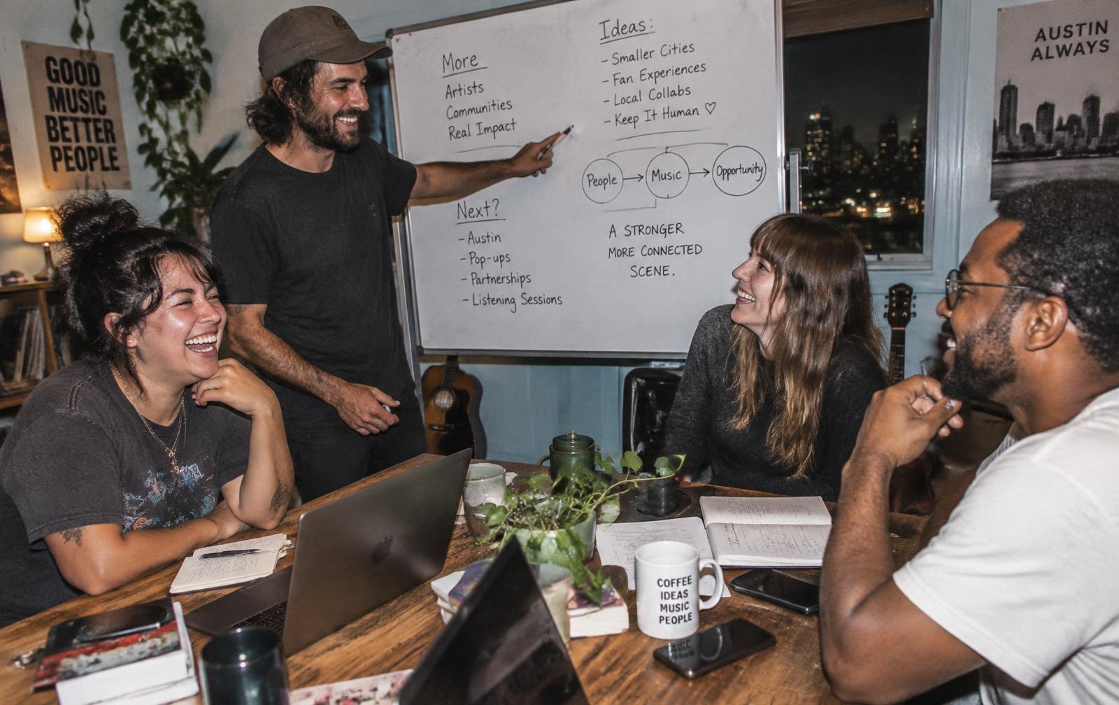 Sellers arguing over an idea at a whiteboard during an Earl Jam session
