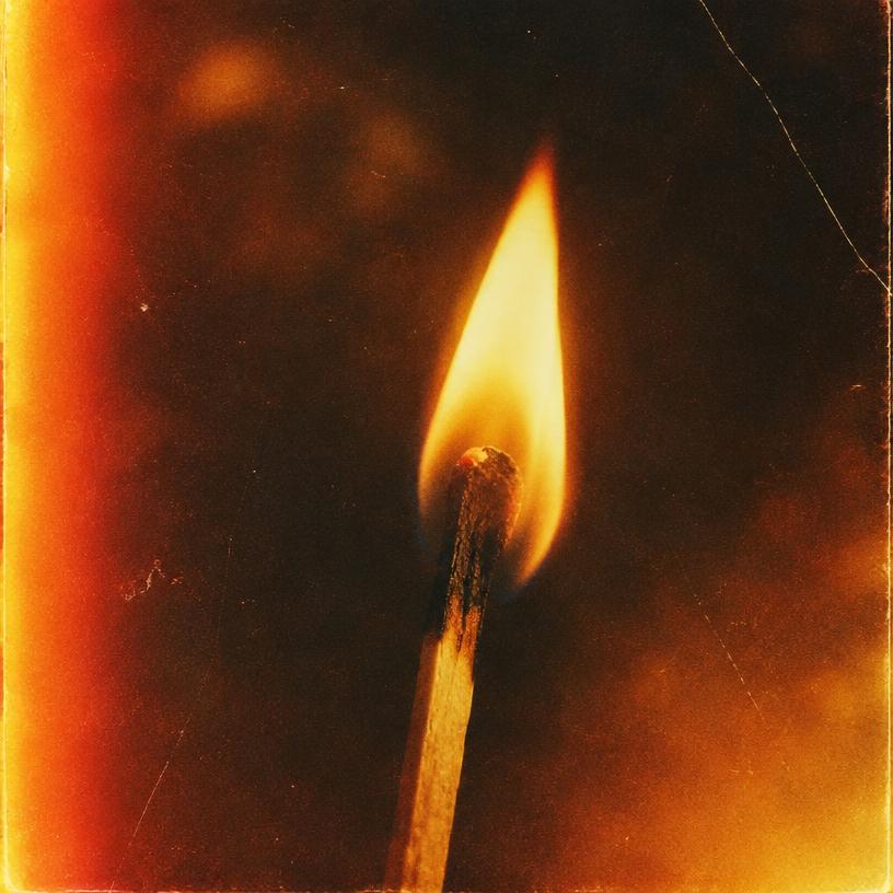 Grainy film photo of a burning match